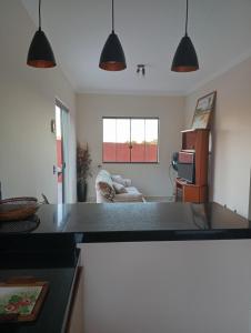 a kitchen with a counter top and a living room at Casa da Serra in Serra Negra +77 photos