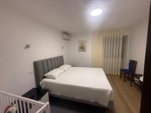 a bedroom with a white bed and a blue chair at Quinta da Raiz in Canedo de Basto