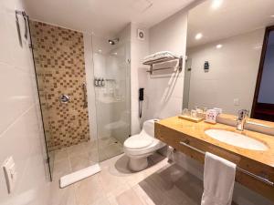 a bathroom with a toilet and a sink and a shower at Hotel Estelar Calle 100 in Bogotá +21 photos