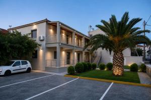 a white car parked in a parking lot in front of a house at Studio vasiliki in Myrina