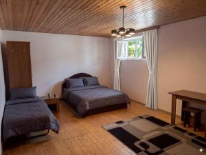 a bedroom with a bed and a desk and a window at HUSAYN HoSTEL in Xirdalan