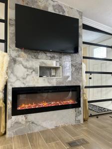 a fireplace with a flat screen tv on a stone wall at Loeras Inn in Dumfries