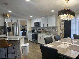 a kitchen with white cabinets and a table with chairs at Loeras Inn in Dumfries