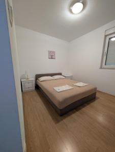 a bedroom with a bed in a white room at Apartman Viva Family in Baška Voda