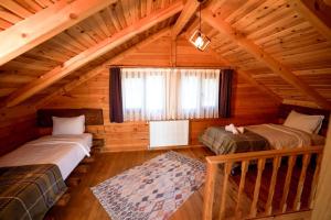 a room with two beds in a log cabin at Oşvacu Dağ Evleri in Çamlıhemşin