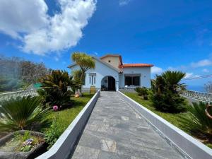 a house with a pathway in front of it at Villa do Monte in Porto Moniz