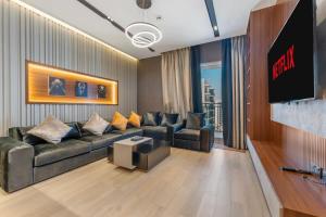 a living room with a couch and a flat screen tv at Yas Island Luxury Apartment by City homes in Yas Island