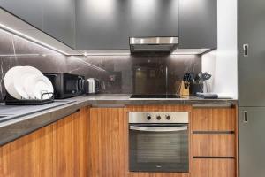a kitchen with a stove and a microwave at Yas Island Luxury Apartment by City homes in Yas Island