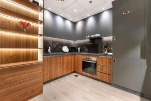 a kitchen with wooden cabinets and a stainless steel refrigerator at Yas Island Luxury Apartment by City homes in Yas Island +19 photos