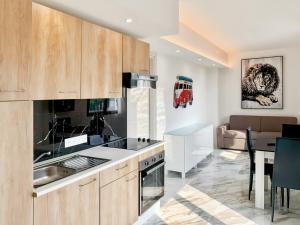 a kitchen with wooden cabinets and a dining room at Mermaid Beach in Roquebrune-Cap-Martin