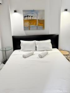 a white bed with two white towels on it at Mermaid Beach in Roquebrune-Cap-Martin