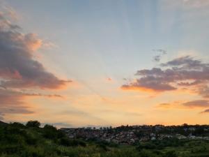 a view of a city from a hill at sunset at Avenue Apartment Sarajevo in Sarajevo