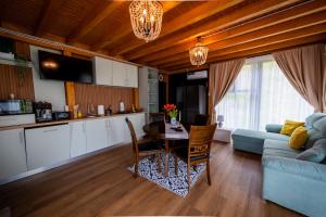eine Küche und ein Wohnzimmer mit einem Tisch und einem Sofa in der Unterkunft Rose Romantic in Tărlungeni