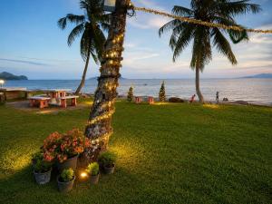 a park with palm trees and a picnic table with flowers at Ava Beach Pakbara in Ban Pak Ba Ra