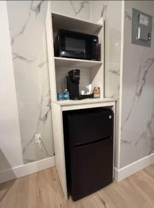 a small kitchen with a microwave and a black dishwasher at Bay Ridge ApartHotel in Brooklyn