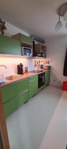 a kitchen with green cabinets and a stove at Grund in Ólafsvík in Ólafsvík