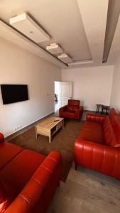 a living room with red furniture and a flat screen tv at Havre de paix in Dakar +2 photos