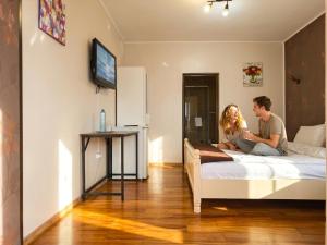 a man and a woman sitting on a bed at Anna ByTheSea By iVAVev in Eforie Sud