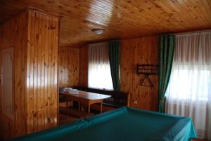 a room with a table and a wooden wall at Дім дача біля води in Protsev