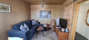 a living room with a blue couch and a tv at Grund in Ólafsvík in Ólafsvík