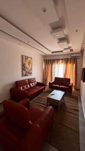 a living room with brown leather couches and a table at Havre de paix in Dakar