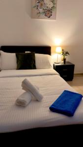 a white bed with a blue towel on it at Arithea Hidden Seaside Heritage 2BR Suite in Paphos