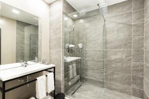 a bathroom with a shower and a sink at Fiesta Royale Hotel in Accra +36 photos