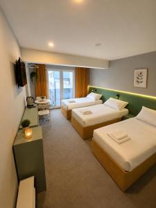 a hotel room with two beds and a television at Boutique Hotel Bora in Peje