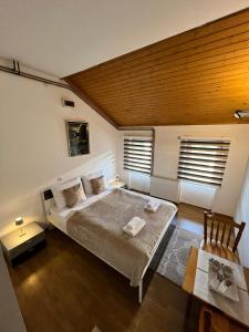 a bedroom with a large bed and a wooden ceiling at Vlašić Moon Apartments in Vlasic