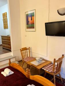 a room with a table and two chairs and a tv at Vlašić Moon Apartments in Vlasic