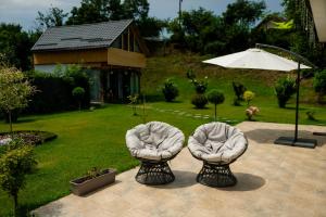 zwei weiße Stühle auf einer Terrasse in einem Hof in der Unterkunft Rose Romantic in Tărlungeni