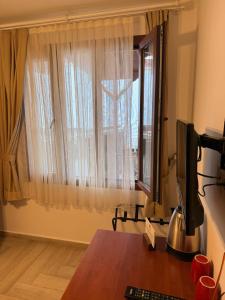 a room with a desk with a computer and a window at Ceren pansiyon in Seferihisar