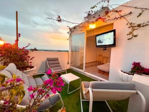 a balcony with chairs and a tv on a building at Las Casitas de Cullera Sol y Mar in Cullera