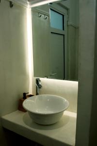a bathroom with a white sink and a mirror at Lyra Apartments Tilos in Livadia