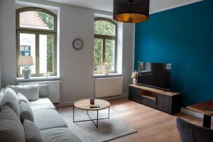 a living room with a couch and a tv at Altstadtquartier Grimma in Grimma