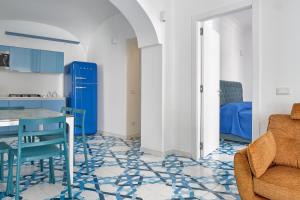a kitchen and living room with blue cabinets and a table and chairs at Maison Blu Royal in Amalfi +17 photos
