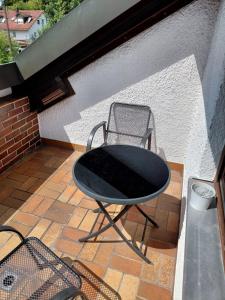 a black table and chair sitting on a patio at Pension Hofmann in Gröbenzell