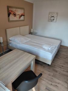 a bedroom with a bed and a desk and a chair at Pension Hofmann in Gröbenzell