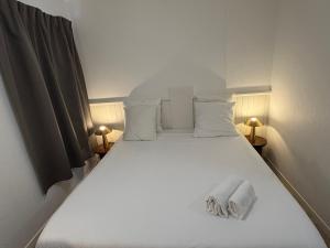 a bedroom with a bed with towels on it at Cit'Hôtel du Parc in Carrières-sous-Poissy