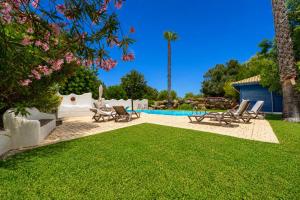 a yard with chairs and a swimming pool at Quinta dos Cochichos - Country Houses in Olhão