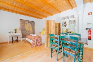 a bedroom with a bed and a table and chairs at Quinta dos Cochichos - Country Houses in Olhão