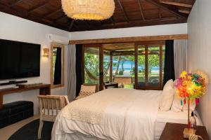 a bedroom with a large bed and a television at Amaia Trancoso Hotel in Trancoso