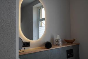 a bathroom with a round mirror on the wall at Altstadtquartier Grimma in Grimma +30 photos