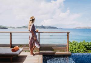 a woman standing on a deck looking out at the ocean at Hotel Christopher Saint Barth in Pointe Milou +116 photos
