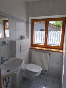 a bathroom with a sink and a toilet and a window at Ferienhaus Anni in Warngau
