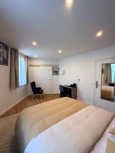 a bedroom with a large bed and a desk at Laulique in Les Lilas