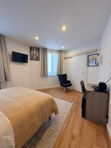 a bedroom with a bed and a desk and a chair at Laulique in Les Lilas