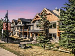 a large house with a sign in front of it at Rocky Mountain Condo with views of Grotto Mtn and hot tub in Dead Man's Flats +29 photos