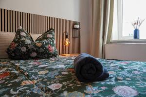 a bed with pillows and a hat on top of it at Altstadtquartier Grimma in Grimma