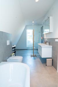 a white bathroom with a sink and a toilet at DAS ANTON - Penthouse mit Seeblick und kostenloser Garage in Gmunden
